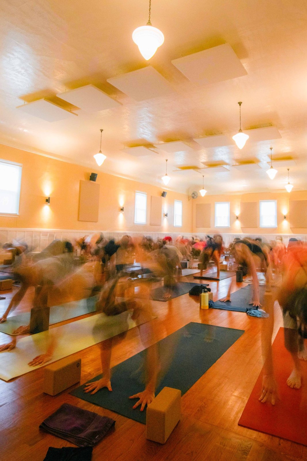 Long-exposure photo of a vinyasa yoga flow class in motion at The Castro Room